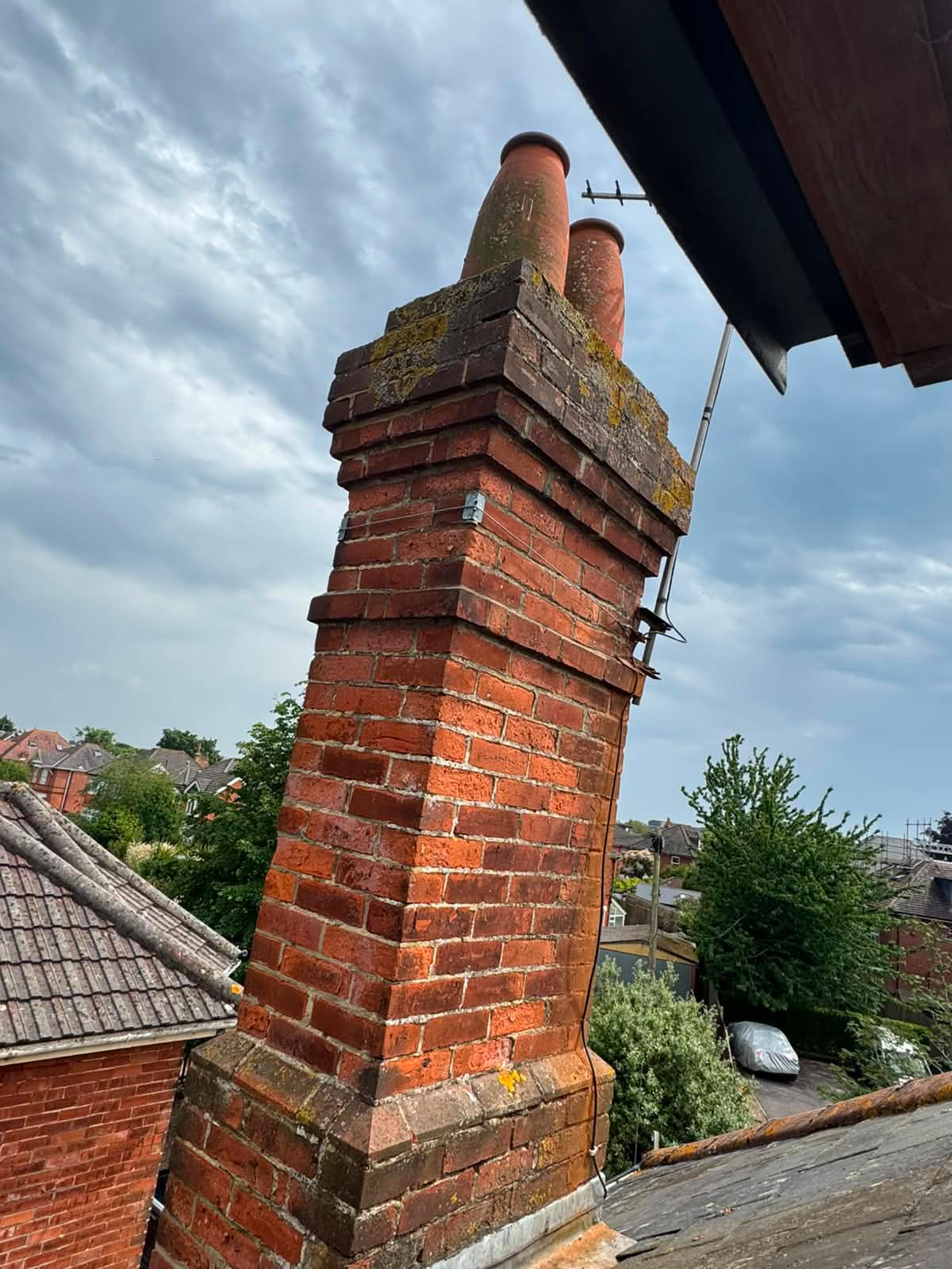 Repointed brick chimney stack with clay pots