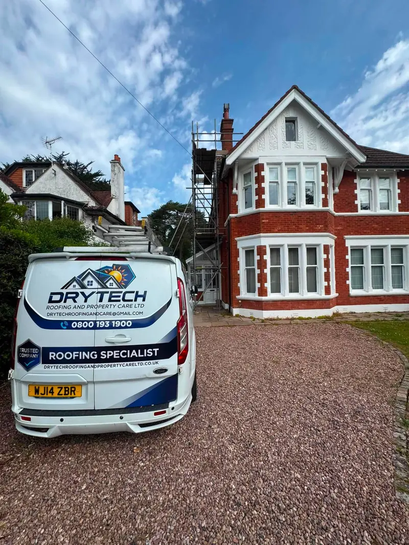 Drytech van outside a red-brick house with scaffold