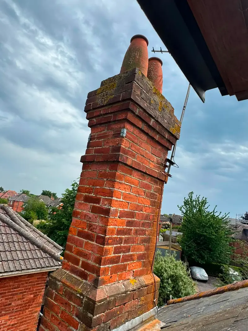 Repointed brick chimney stack with clay pots